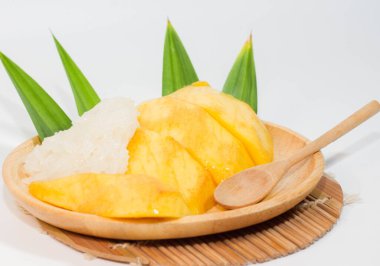 Tahta bir tabakta mango pilavı ve tahta bir kaşık, beyaz arka plan..