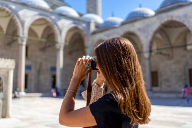 Güneşli bir günde Süleyman Camii 'nin fotoğrafını çeken kahverengi saçlı turist kadın. Seyahat ve aktif yaşam tarzı, yaz tatili konsepti.