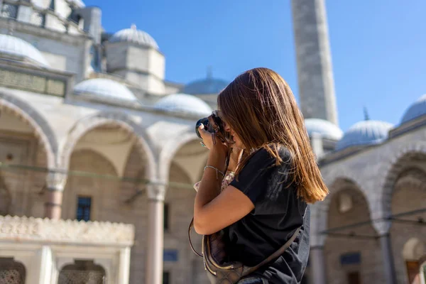 Güneşli bir günde Süleyman Camii 'nin fotoğrafını çeken kahverengi saçlı turist kadın. Seyahat ve aktif yaşam tarzı, yaz tatili konsepti.