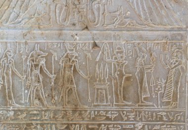 Rahibe Takerseb 'in (sağdan sola) Osiris, Min, Horus, Anubis, Isis ve Metis' e adak adaması konusunda Stele 'yi rahatlat. Batlamyus Dönemi, MÖ 332-30, Mısır. İstanbul Arkeoloji Müzesi.