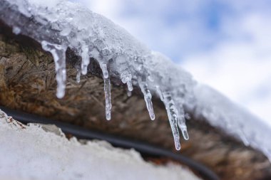 Tahta çatıda küçük buz sarkıtları asılı..
