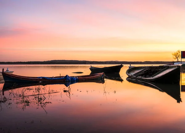 日出时带着几艘被遗弃的船欣赏湖面宁静的景色 — 图库照片