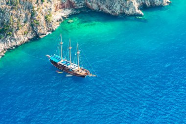 Kelebek Vadisi 'nin derin mavi denizinde güzel ahşap yelkenlinin hava aracı görüntüsü, Fethiye, Türkiye