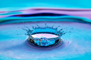 Renkli arkaplanda su sıçraması izole edildi.