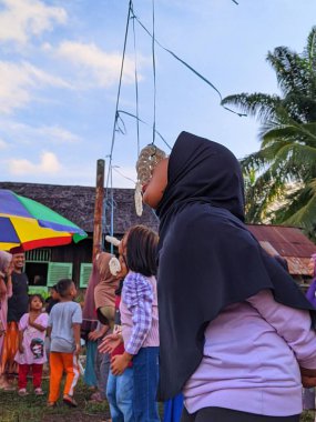the excitement of adults and children taking part in a cracker eating competition to enliven the independence day of the republic of Indonesia, East Kalimantan, Indonesia August 13, 2022