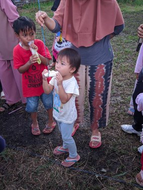 the excitement of adults and children taking part in a cracker eating competition to enliven the independence day of the republic of Indonesia, East Kalimantan, Indonesia August 13, 2022