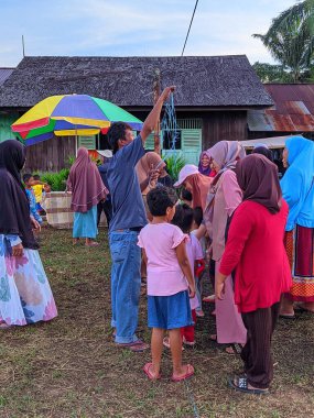 the excitement of adults and children taking part in a cracker eating competition to enliven the independence day of the republic of Indonesia, East Kalimantan, Indonesia August 13, 2022