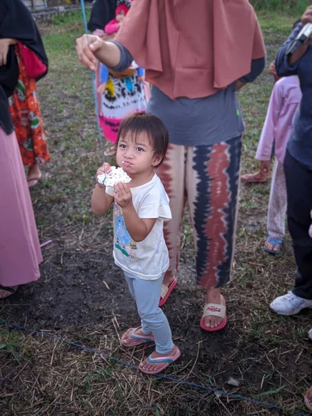 the excitement of adults and children taking part in a cracker eating competition to enliven the independence day of the republic of Indonesia, East Kalimantan, Indonesia August 13, 2022
