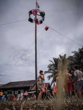 the excitement of children and adults taking part in the areca climbing competition to enliven the independence day of the republic of Indonesia, east kalimantan, indonesia, august, 14,2022
