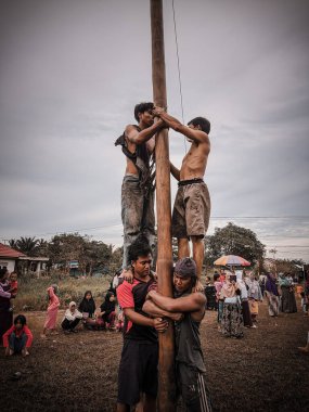 the excitement of children and adults taking part in the areca climbing competition to enliven the independence day of the republic of Indonesia, east kalimantan, indonesia, august, 14,2022