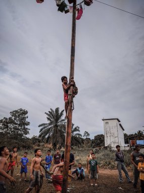 the excitement of children and adults taking part in the areca climbing competition to enliven the independence day of the republic of Indonesia, east kalimantan, indonesia, august, 14,2022