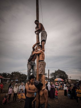 the excitement of children and adults taking part in the areca climbing competition to enliven the independence day of the republic of Indonesia, east kalimantan, indonesia, august, 14,2022