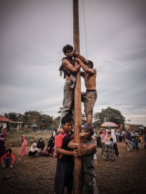 the excitement of children and adults taking part in the areca climbing competition to enliven the independence day of the republic of Indonesia, east kalimantan, indonesia, august, 14,2022