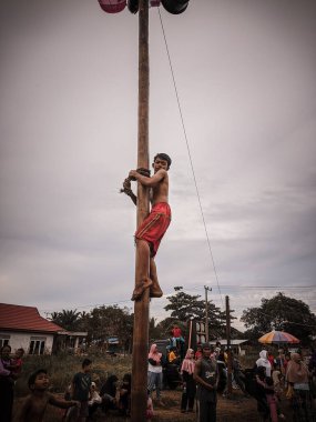 the excitement of children and adults taking part in the areca climbing competition to enliven the independence day of the republic of Indonesia, east kalimantan, indonesia, august, 14,2022