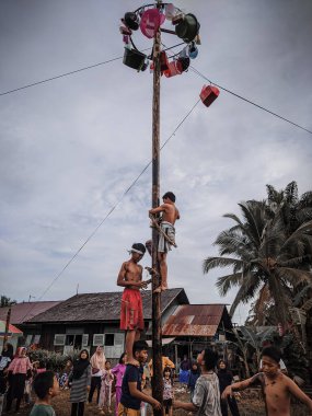 the excitement of children and adults taking part in the areca climbing competition to enliven the independence day of the republic of Indonesia, east kalimantan, indonesia, august, 14,2022