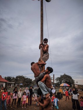 the excitement of children and adults taking part in the areca climbing competition to enliven the independence day of the republic of Indonesia, east kalimantan, indonesia, august, 14,2022