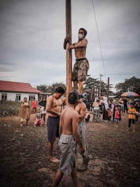 the excitement of children and adults taking part in the areca climbing competition to enliven the independence day of the republic of Indonesia, east kalimantan, indonesia, august, 14,2022