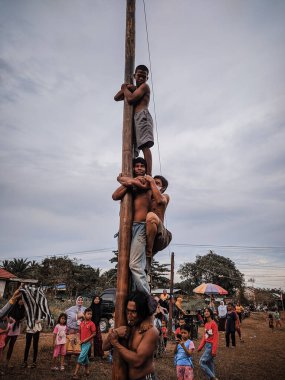 the excitement of children and adults taking part in the areca climbing competition to enliven the independence day of the republic of Indonesia, east kalimantan, indonesia, august, 14,2022