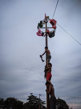 the excitement of children and adults taking part in the areca climbing competition to enliven the independence day of the republic of Indonesia, east kalimantan, indonesia, august, 14,2022