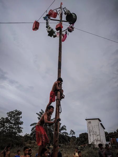 the excitement of children and adults taking part in the areca climbing competition to enliven the independence day of the republic of Indonesia, east kalimantan, indonesia, august, 14,2022