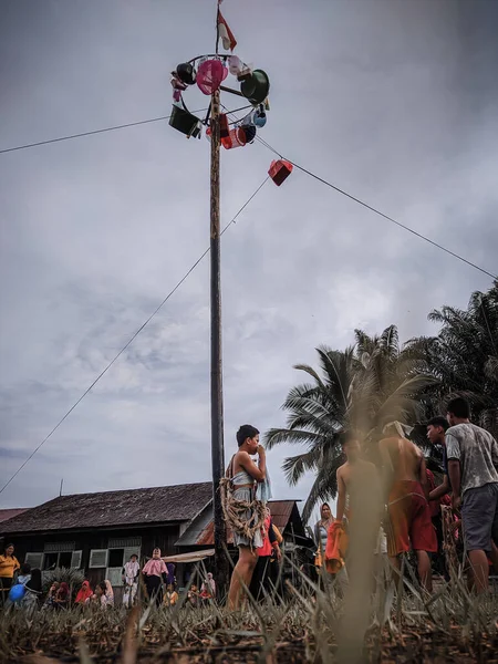 the excitement of children and adults taking part in the areca climbing competition to enliven the independence day of the republic of Indonesia, east kalimantan, indonesia, august, 14,2022