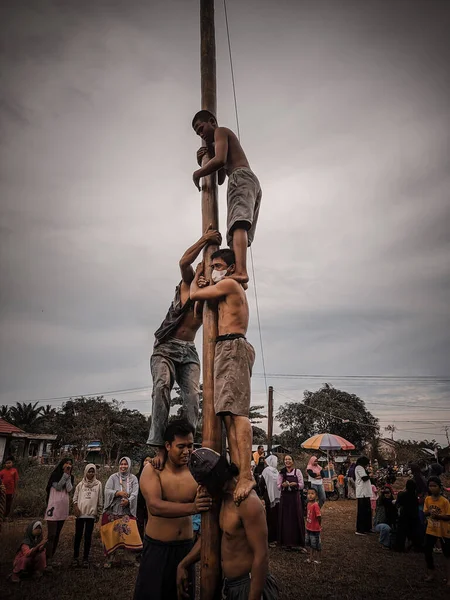 the excitement of children and adults taking part in the areca climbing competition to enliven the independence day of the republic of Indonesia, east kalimantan, indonesia, august, 14,2022