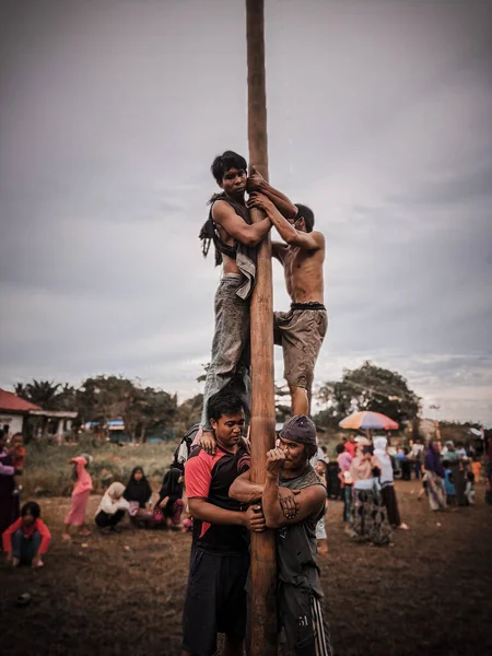 the excitement of children and adults taking part in the areca climbing competition to enliven the independence day of the republic of Indonesia, east kalimantan, indonesia, august, 14,2022