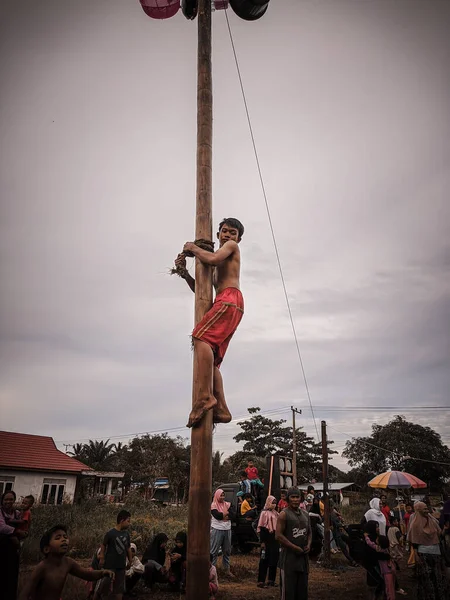 the excitement of children and adults taking part in the areca climbing competition to enliven the independence day of the republic of Indonesia, east kalimantan, indonesia, august, 14,2022