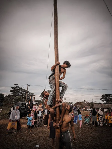 the excitement of children and adults taking part in the areca climbing competition to enliven the independence day of the republic of Indonesia, east kalimantan, indonesia, august, 14,2022