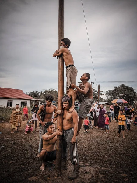 the excitement of children and adults taking part in the areca climbing competition to enliven the independence day of the republic of Indonesia, east kalimantan, indonesia, august, 14,2022