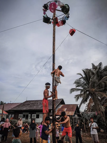 the excitement of children and adults taking part in the areca climbing competition to enliven the independence day of the republic of Indonesia, east kalimantan, indonesia, august, 14,2022