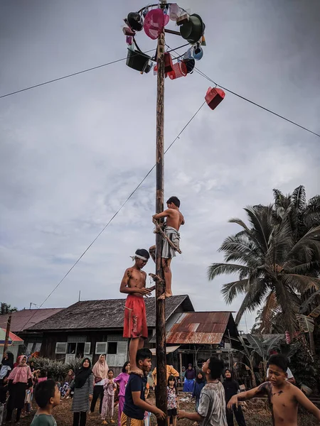 the excitement of children and adults taking part in the areca climbing competition to enliven the independence day of the republic of Indonesia, east kalimantan, indonesia, august, 14,2022