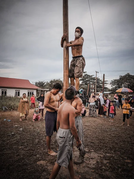 the excitement of children and adults taking part in the areca climbing competition to enliven the independence day of the republic of Indonesia, east kalimantan, indonesia, august, 14,2022