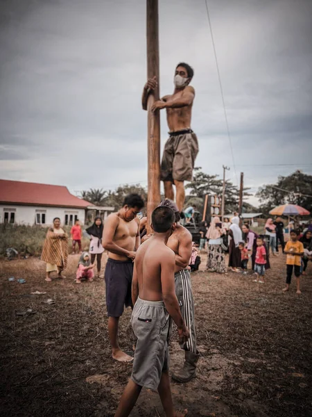 the excitement of children and adults taking part in the areca climbing competition to enliven the independence day of the republic of Indonesia, east kalimantan, indonesia, august, 14,2022