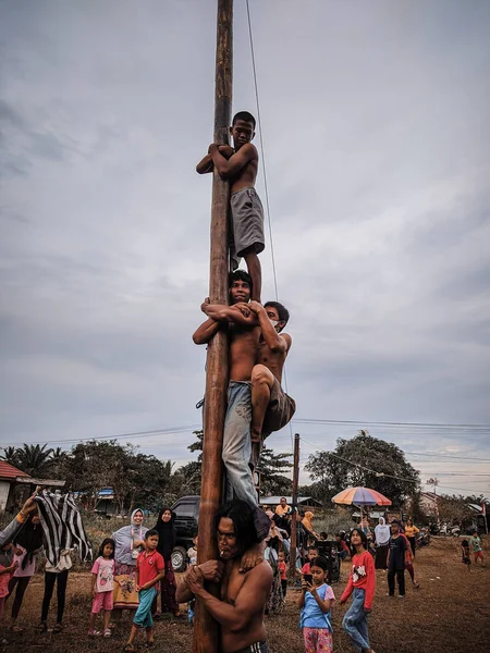 the excitement of children and adults taking part in the areca climbing competition to enliven the independence day of the republic of Indonesia, east kalimantan, indonesia, august, 14,2022