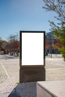 Kaldırımda siyah çerçeveli dikey ilan panosu. Model yap, sokaklarda kaldırımlı boş beyaz afiş.