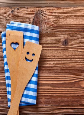 Mutfak gereçleri ve havlu ahşap bir masada.