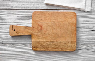 Tahta bir masanın üzerindeki boş kesme tahtası