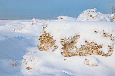 Turkuaz suyun yanında gri taşlar yığını