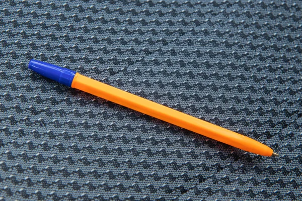 Orangefarbener Stift liegt auf dunklem Autositz — Stockfoto