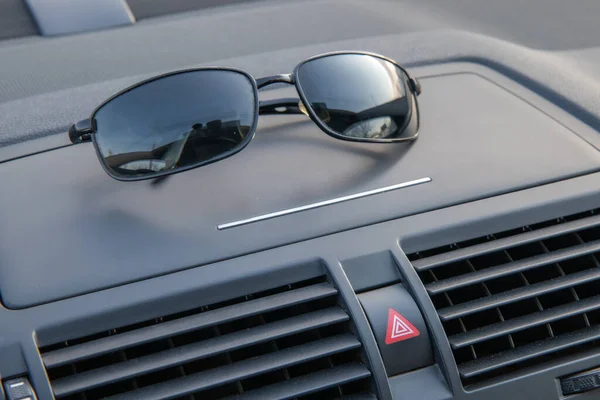 Gafas de sol se encuentran en el salpicadero del coche — Foto de Stock