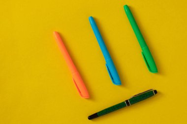 Kırtasiye malzemesi, sarı arka planda renkli işaretler. Ofis ögeleri