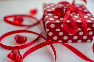 Red gift box with white polka dots and a red ribbon 