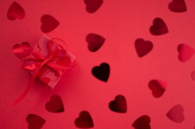 Red giftbox on red background for Valentine's Day.
