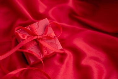 Red giftbox on red background for Valentine's Day.