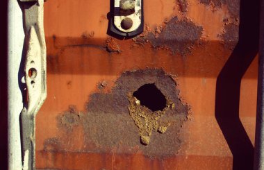 Çürük delikli paslı konteynır.