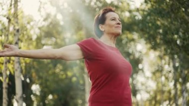 Yaşlı kadın doğa üzerinde egzersiz yapıyor.