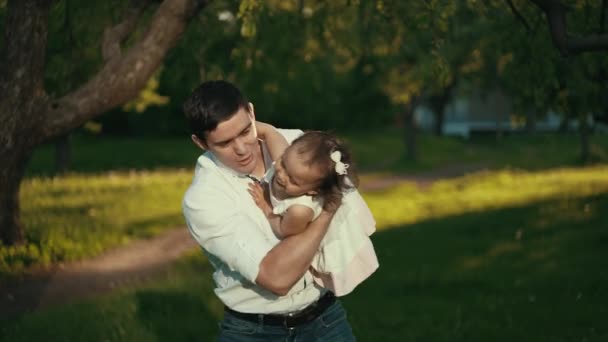 Far med lille pige leger på solnedgang – Stock-video
