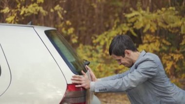 Bozuk bir arabayı iten adam