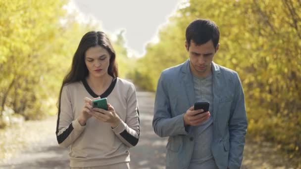 Caminhando casal com smartphones em mãos — Vídeo de Stock